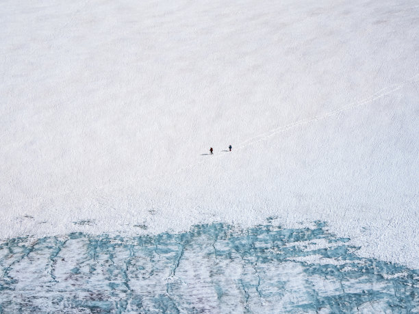 沿着冰川走下去。冬天在白雪皑皑的山上徒步旅行。极限娱乐和山地旅游。图片下载