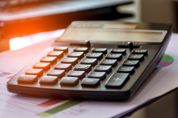 模拟计算器和图表数据纸在办公室的桌子上。办公用品的概念。图片下载