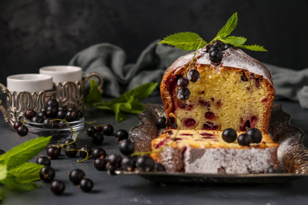 黑醋栗纸杯蛋糕位于一个托盘，在黑暗的背景，水平照片图片下载