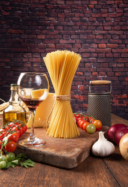 意大利面(通心粉)，用剑麻细绳绑在一起的意大利面，一杯红酒，西红柿，橄榄油，奶酪和香料，在乡村木材上，选择性的焦点。图片下载