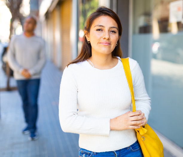 满意的拉丁妇女穿着休闲装在户外微笑。图片下载