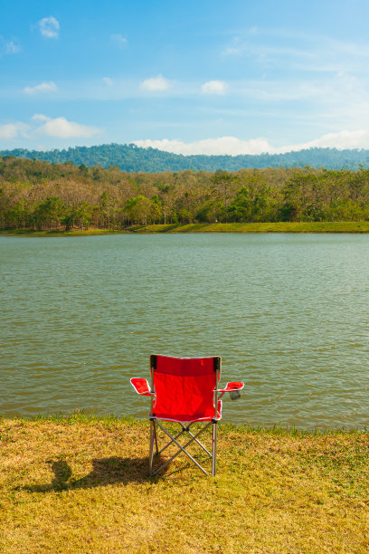 自然公园湖边草地上独坐红椅子图片下载