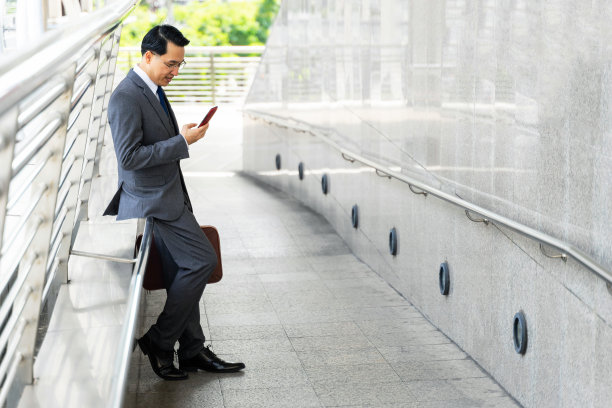 亚洲男人用智能手机感受快乐的生活方式商业街区都市生活商业人的概念图片下载