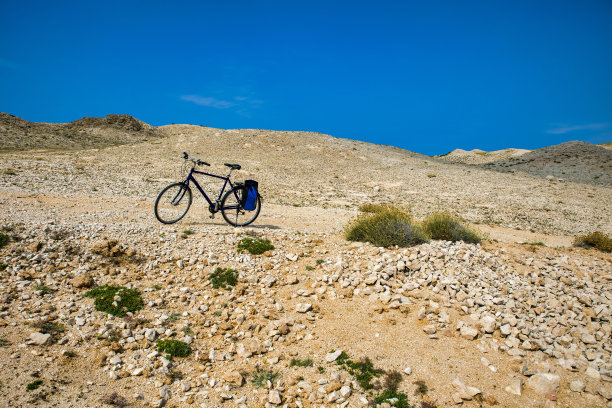 一辆孤独的自行车在克罗地亚帕格岛贫瘠的风景前图片下载