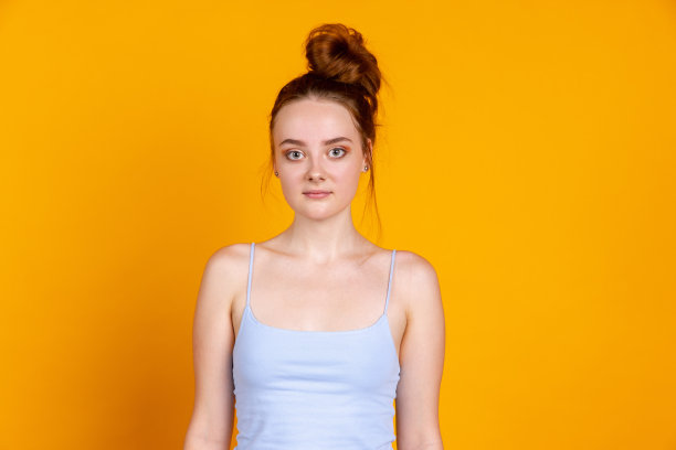 甜美的年轻漂亮的女孩孤立在黄色工作室背景。女性时装模特在休闲服装。人类情感的概念，面部表情，自然美，青春图片下载