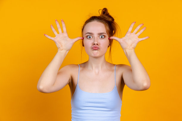 年轻漂亮的女孩孤立在黄色工作室背景。女性时装模特在休闲服装。人类情感的概念，面部表情，自然美，青春图片下载