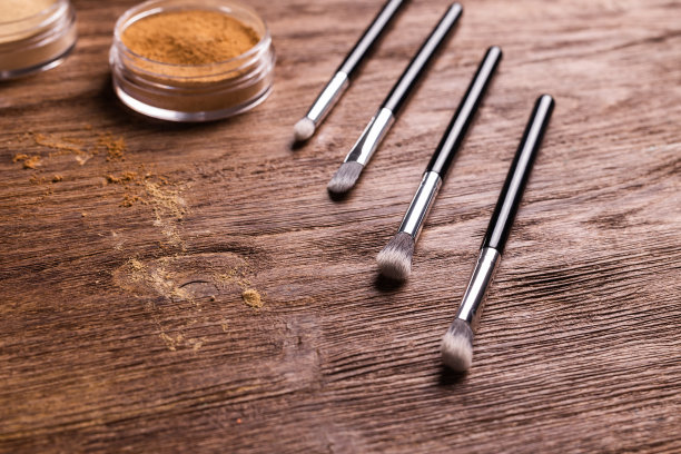 松散的粉状矿物粉末用于脸部和刷子用于木制背景上的粉末和面部。环保有机化妆品。图片下载