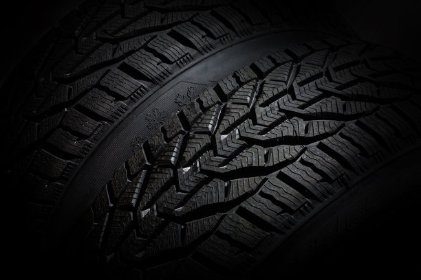 特写汽车轮胎孤立在黑色背景。潮湿的滴轮对黑色图片下载