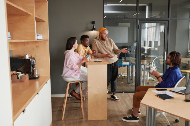 年轻的跨种族同事在共同的办公空间里喝着咖啡，讨论着营销项目图片下载