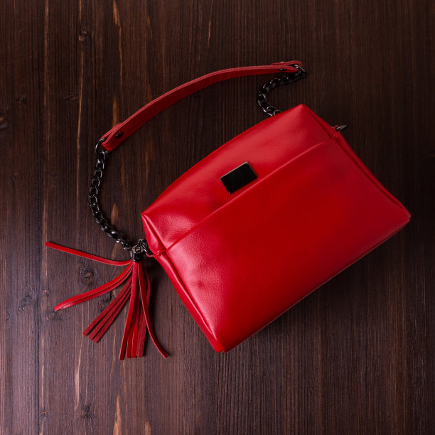 红色皮革包为妇女在一个棕色木材纹理的背景。图片下载