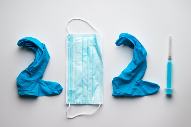 蓝色橡胶医用手套、医用口罩和注射器。医疗用品构成了2021年的题词图片下载