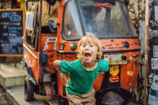 一个男孩在巴厘岛乌布的市场。在印尼著名的乌布市场，典型的纪念品商店出售巴厘岛的纪念品和手工艺品。巴厘岛的市场。当地居民的木制品和工艺品纪念品图片下载