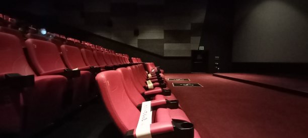 在一个黑暗的电影院里。一个红色的椅子图片下载