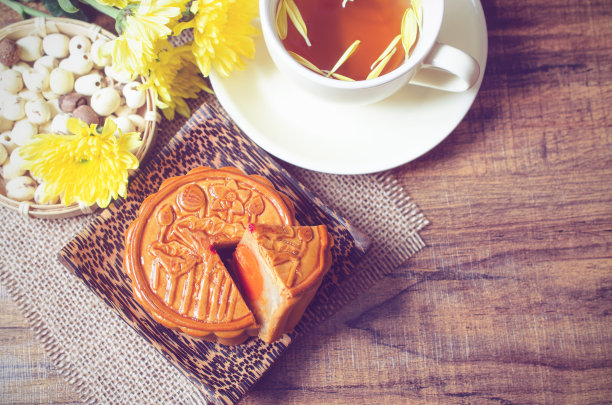 俯视图美味的自制月饼与茶杯和菊花在柔和的复古色调。为中国中秋节庆祝活动的概念图片下载