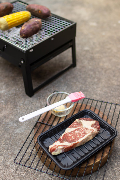 烤里脊牛排，配日本红薯和玉米，放在炭炉上烤。图片下载