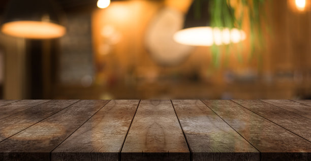 空木制桌面与灯光散景模糊餐厅背景。图片下载
