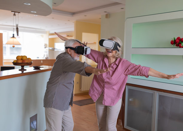 老年夫妇在家中使用虚拟现实模拟器图片下载