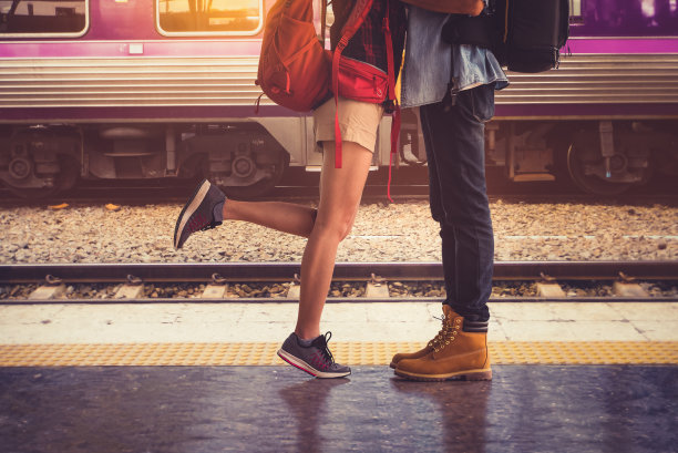 夏日，在温暖的阳光背景下，一对情侣在一个国家的火车站幸福地拥抱着。图片下载