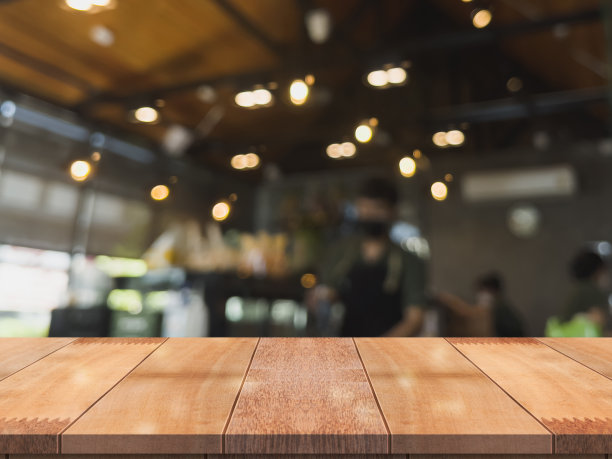 空木制桌面与灯光散景模糊餐厅背景。图片下载