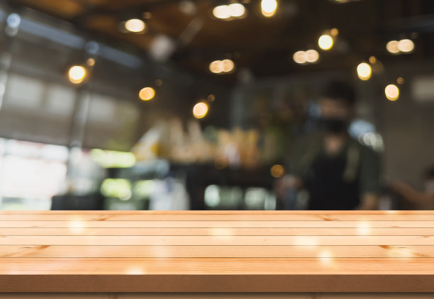 空木制桌面与灯光散景模糊餐厅背景。图片下载