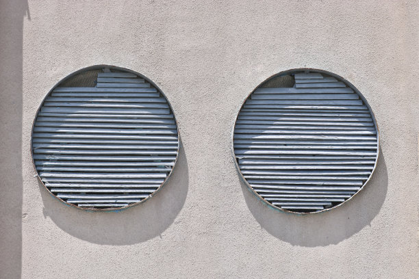 水泥墙上的圆形结构，上面覆盖着开裂的灰泥。图片下载