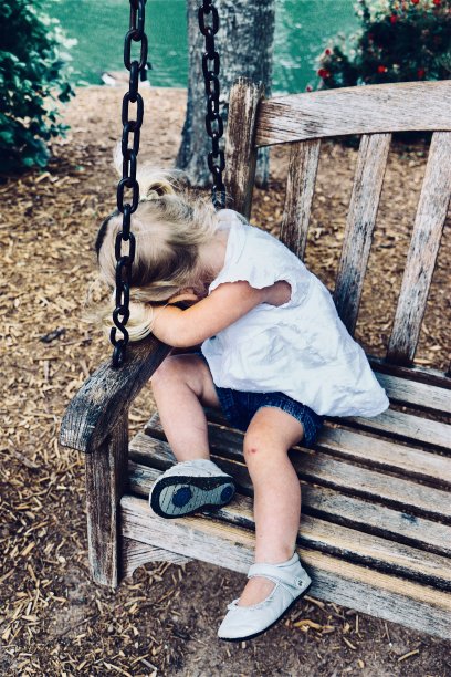 可爱的蹒跚学步的孩子在摇摆的公园长凳上睡着了图片下载