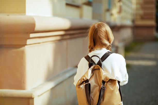 在城市里，小学生穿着运动衫去户外上学图片下载