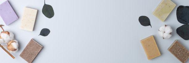 灰色背景上的肥皂和花。平铺，复制空间。图片下载
