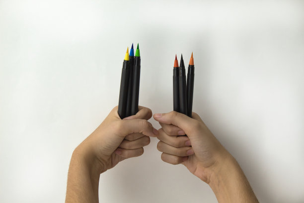 一个女孩手里拿着一把彩色笔和白色背景上的记号笔图片下载