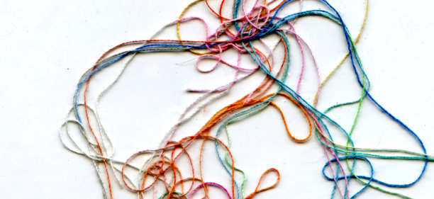 多色纠结彩色绣花丝线。抽象色彩背景，以白色为背景图片下载