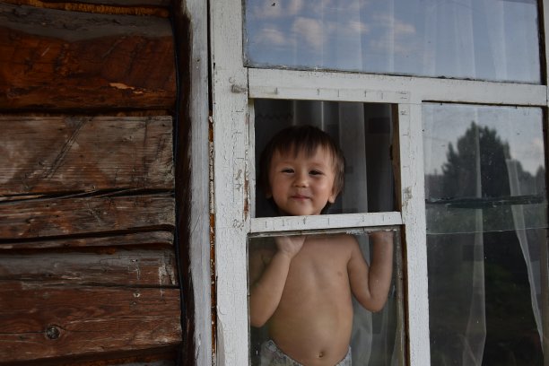 一个小孩向窗外望去图片下载