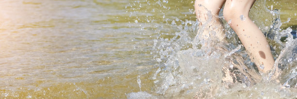 在沙滩上奔跑和跳跃的女孩的腿。长夏季横幅与复制空间。靠近一个年轻女孩的腿走或在海滩上与海浪和海泡沫图片下载