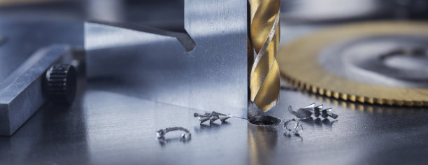 金属钻头用三角尺在工业钻床上在钢坯上钻孔。金属加工行业和锁匠工作。图片下载