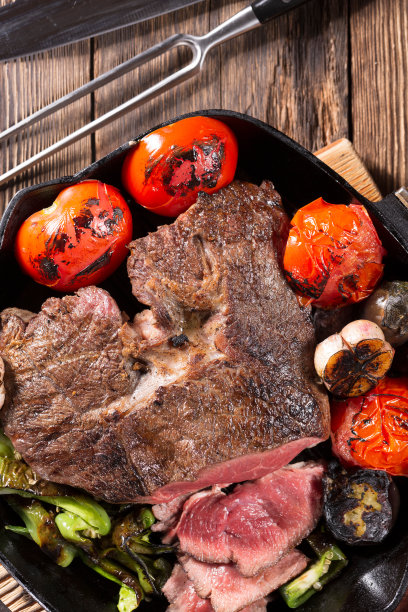 在铸铁平底锅中烤的一块肉和蔬菜图片下载