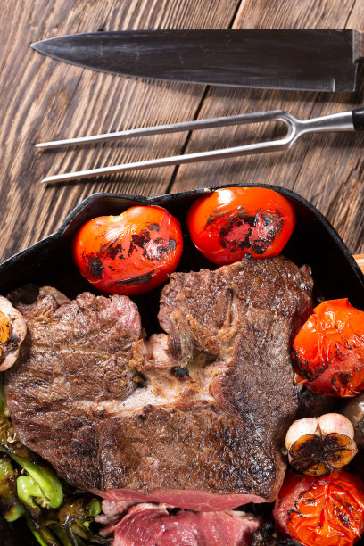 在铸铁平底锅中烤的一块肉和蔬菜图片下载