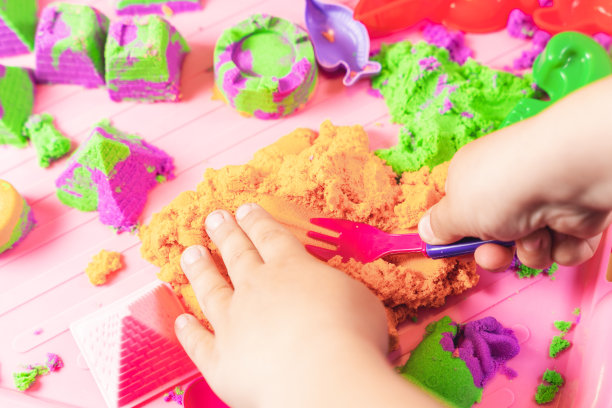 孩子的手在玩五彩的动沙图片下载