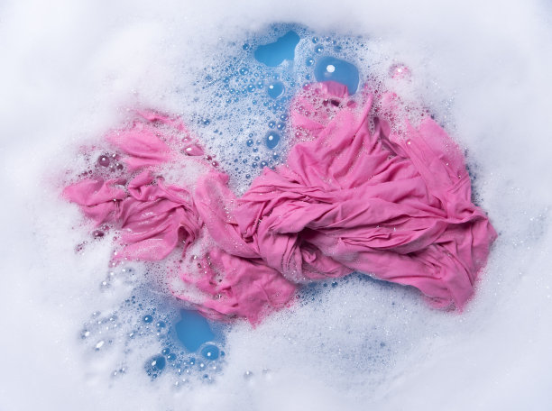 用白色泡沫将彩色衣服浸湿后再洗，俯视图图片下载