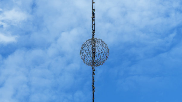 蓝色天空背景上的灯泡花环。空间的文本。抽象的设计构成。蓝色多云的天空背景上有奇怪的物体。图片下载