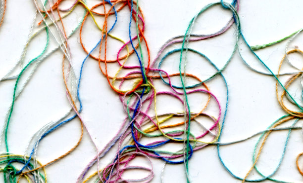 多色纠结彩色绣花丝线。抽象色彩背景，以白色为背景图片下载
