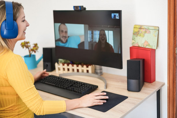 年轻女子在家里用电脑与朋友视频通话-注意右手图片下载