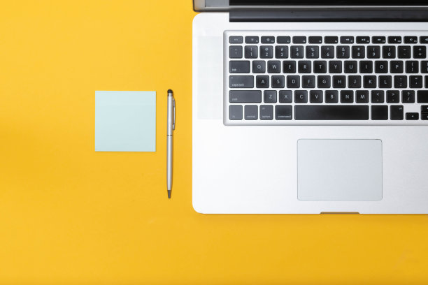 俯视图的笔记本电脑，咖啡和手机在黄色孤立的背景。办公室图片下载