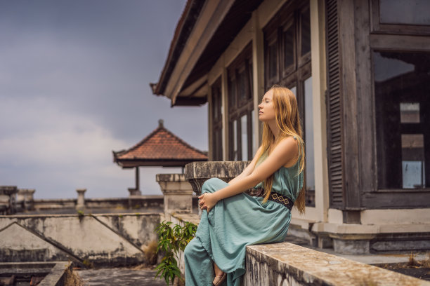 一名女游客在贝都古尔被遗弃的神秘酒店。印度尼西亚,巴厘岛。巴厘岛旅游的概念图片下载