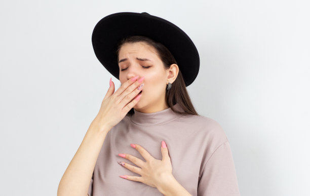 美丽的女人在白色的背景下无聊地打哈欠图片下载