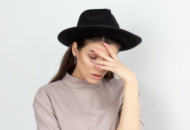 烦恼的时尚的欧洲女孩的肖像做面部手掌手势，感觉无聊，而她的朋友说个不停。肢体语言图片下载