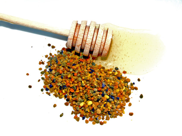生花粉、多花和蜂蜜从一个木制茶匙流出图片下载