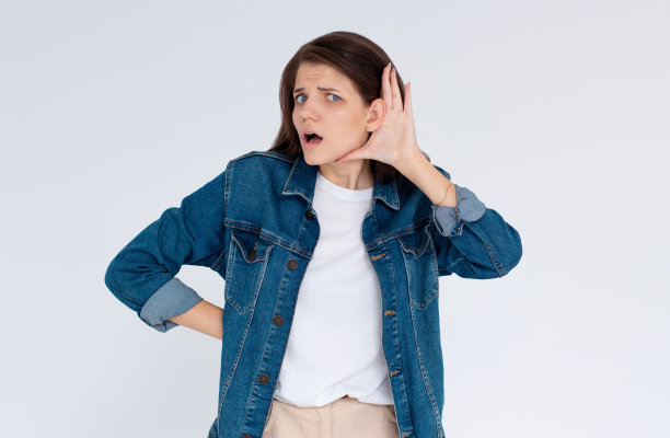 漂亮女人把手放在耳朵上是为了听得更清楚。年轻女孩在白色背景下听着什么图片下载