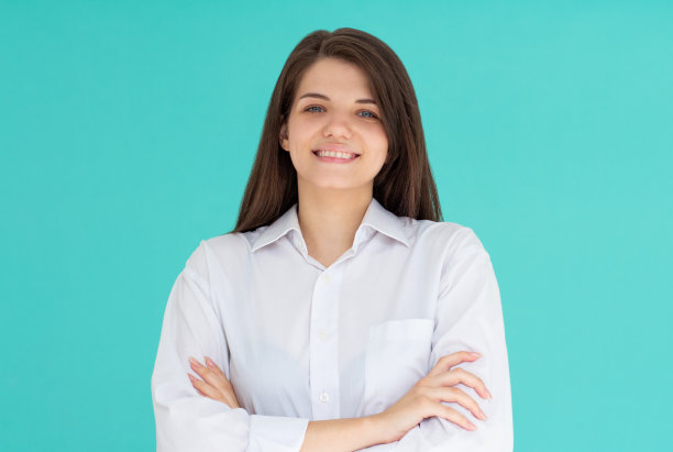 画室里交叉双臂微笑的女商人肖像。图片下载