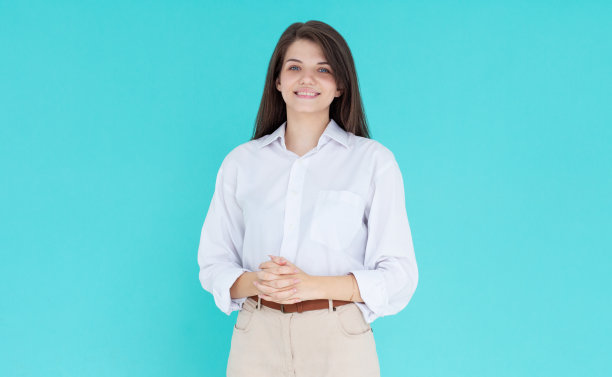 快乐的年轻女商人的形象在蓝色的墙背景上孤立。图片下载