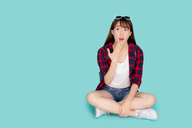 美丽的人像年轻的亚洲女人坐着惊喜穿着旅行夏季时尚与游客在度假孤立的蓝色背景上，亚洲女孩震惊的表情，假期惊人的概念。图片下载