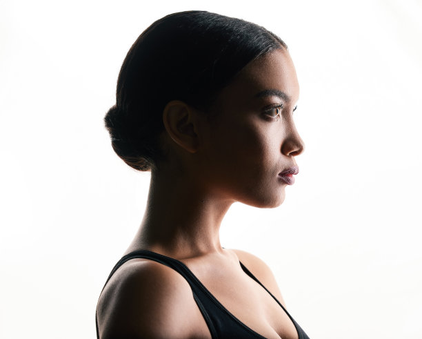 一个美丽的年轻女子在白色背景下摆姿势的剪影图片下载